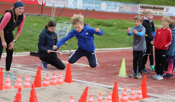 Kinder beim Sprung in den Sand